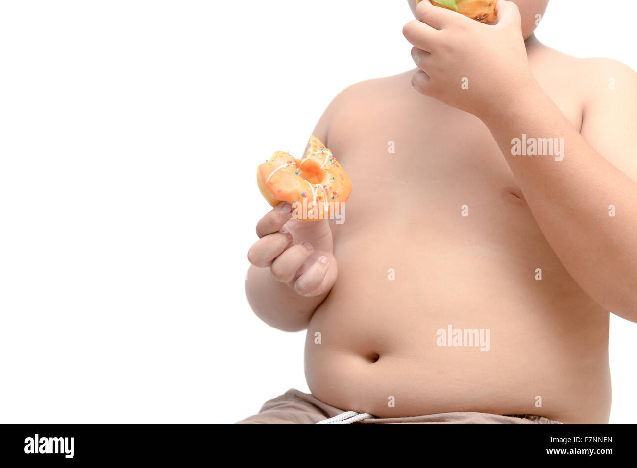 Obese fat boy is holding and eating donut isolated on white background, junk food and dieting concept Stock Photo