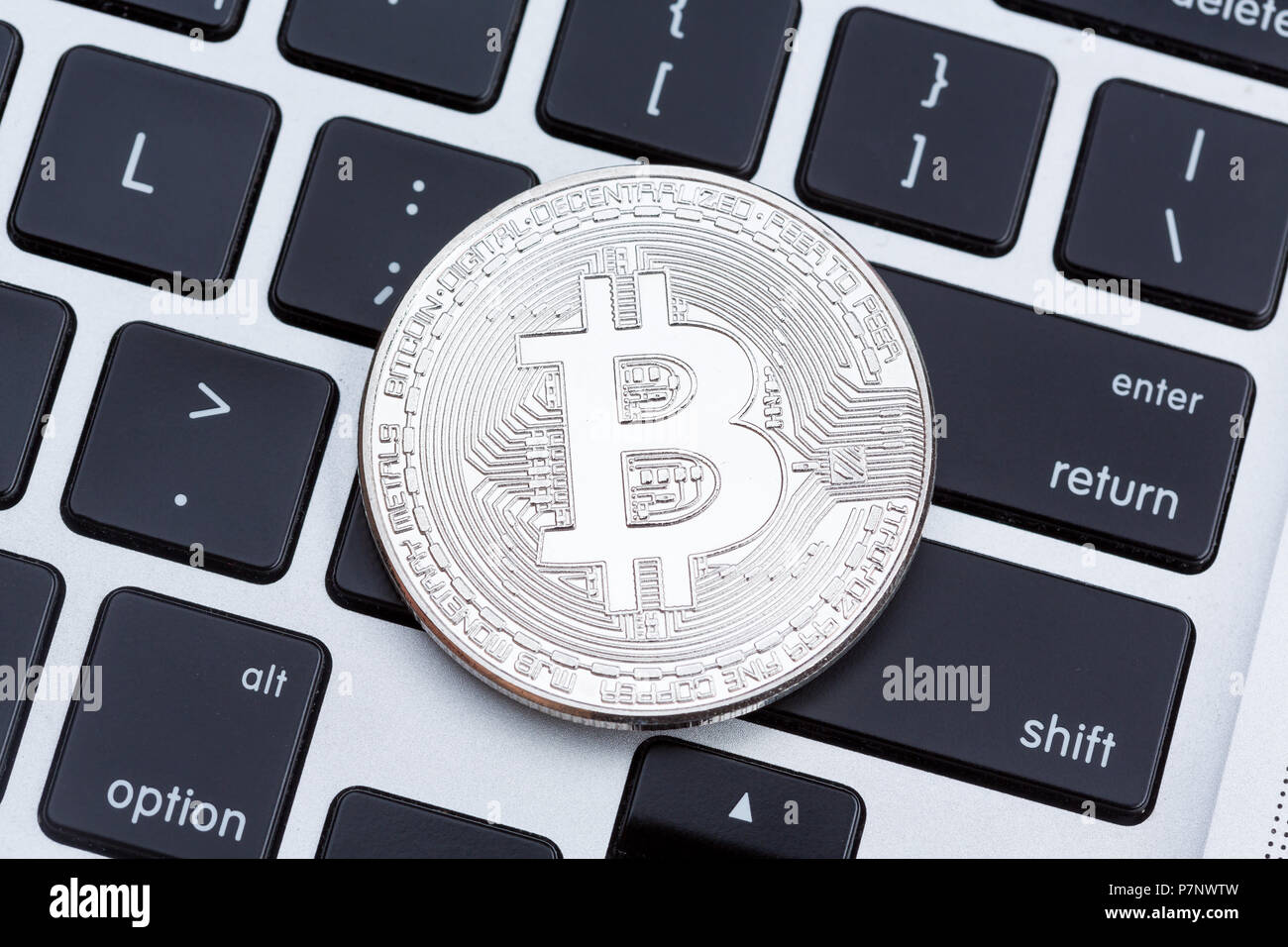 Silver bitcoin isolated on computer key board background. Stock Photo