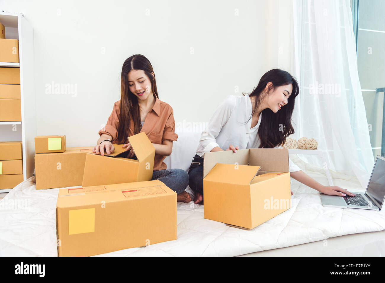 Young Asian woman startup small business entrepreneur SME distribution warehouse with parcel mail box. Owner home office concept. Online marketing and Stock Photo