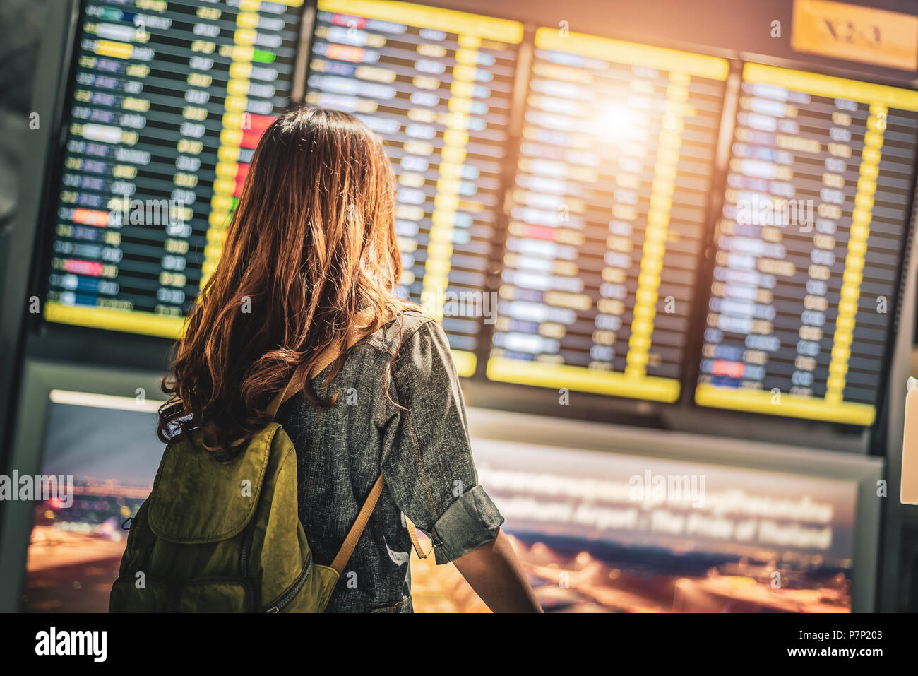 Beauty female tourist looking at flight schedules for checking take off time. People and lifestyles concept. Travel and Happy life of single woman the Stock Photo
