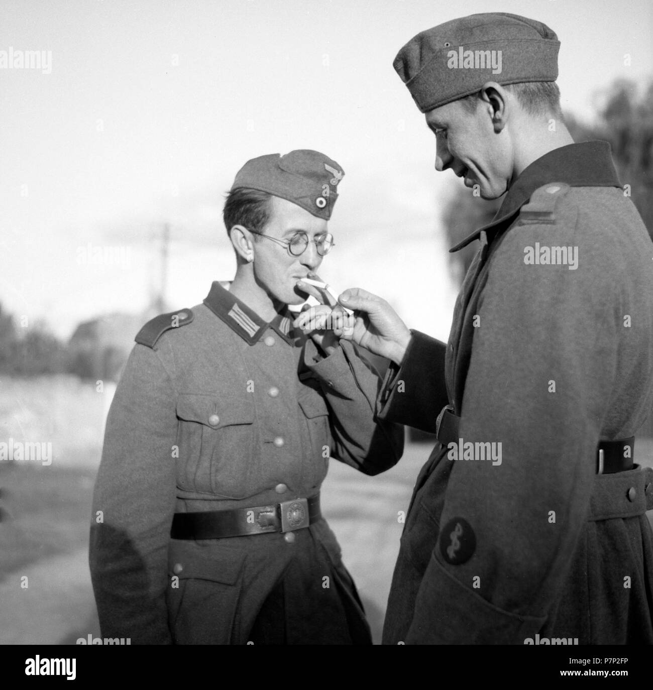 Approx. 1939,1941, training Wehrmacht, soldier hands someone else his cigarette to light, Ulm, Germany Stock Photo