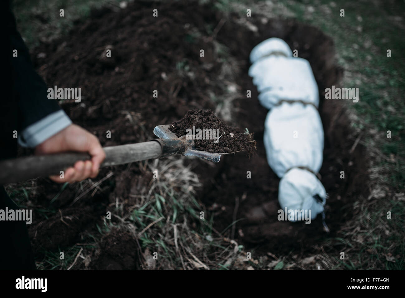 Maniac buries victim into a grave, crime horror Stock Photo