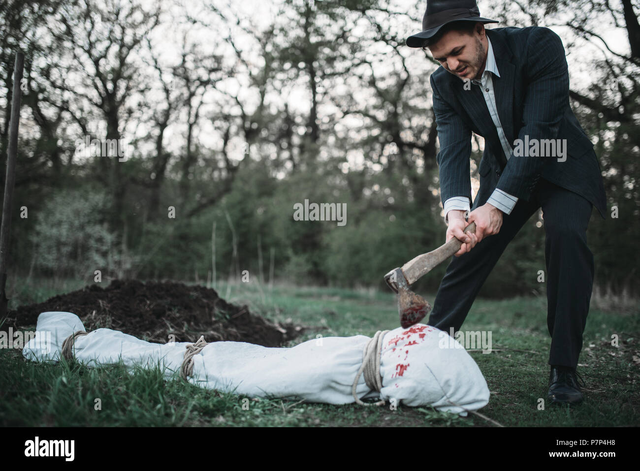 Maniac with an axe, victim wrapped in a canvas Stock Photo