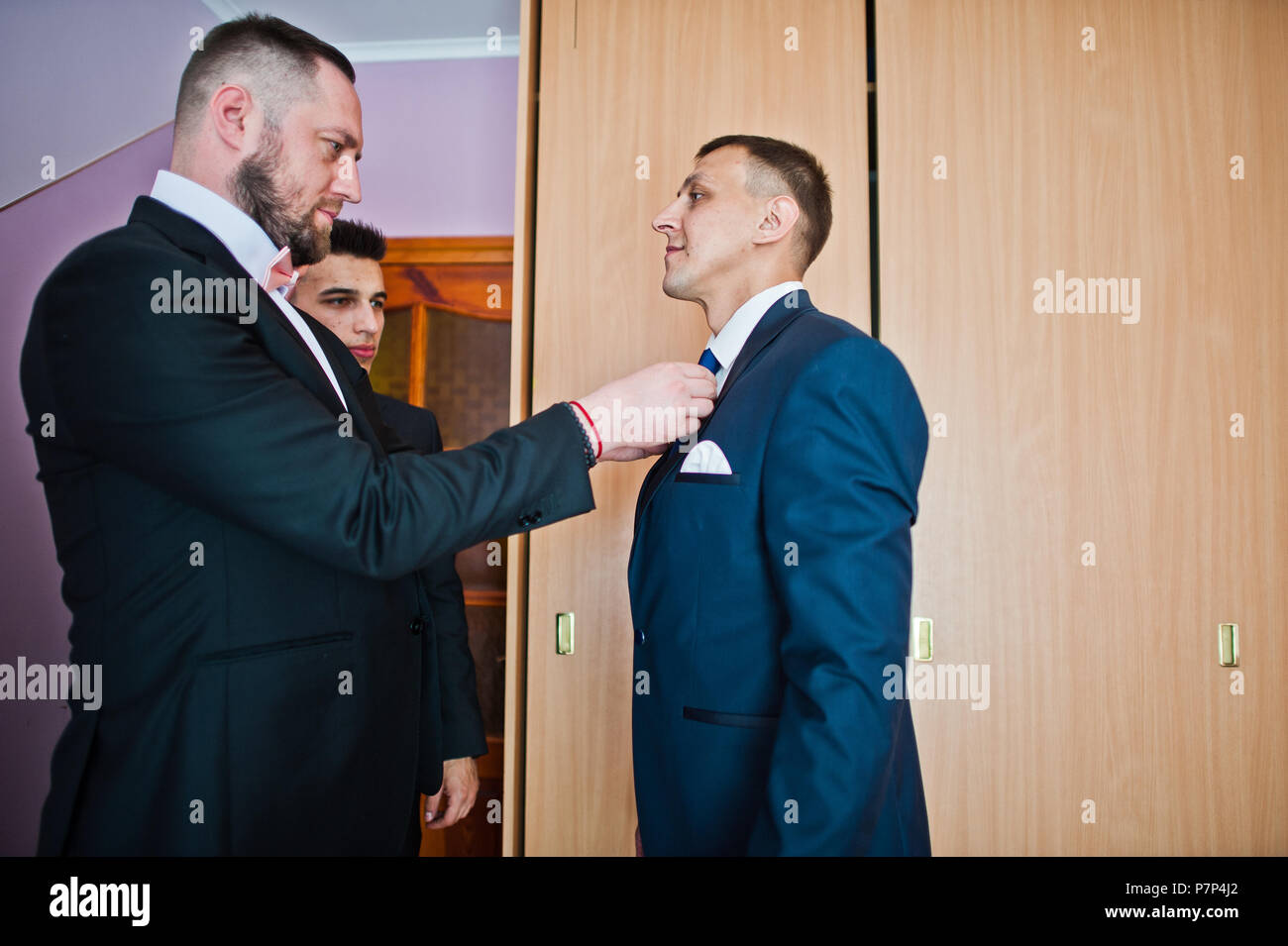 Best man tying a tie on groom's neck before the wedding ceremony Stock ... - Tying A Tie For A Man With A Crew Neck