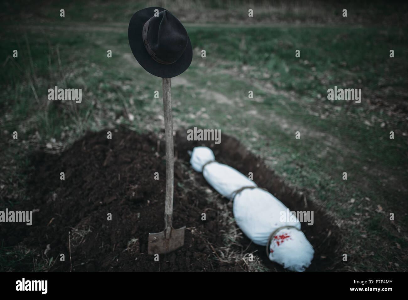 Grave with maniac victim wrapped in a canvas Stock Photo