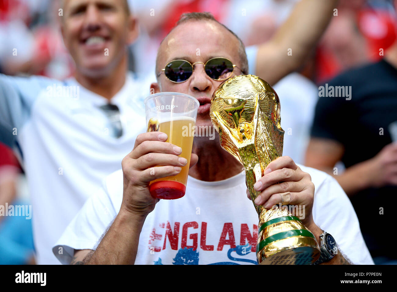 An England fan in the stands holds up a replica of the 2018 FIFA World Cup trophy before the FIFA World Cup, Quarter Final match at the Samara Stadium Stock Photo
