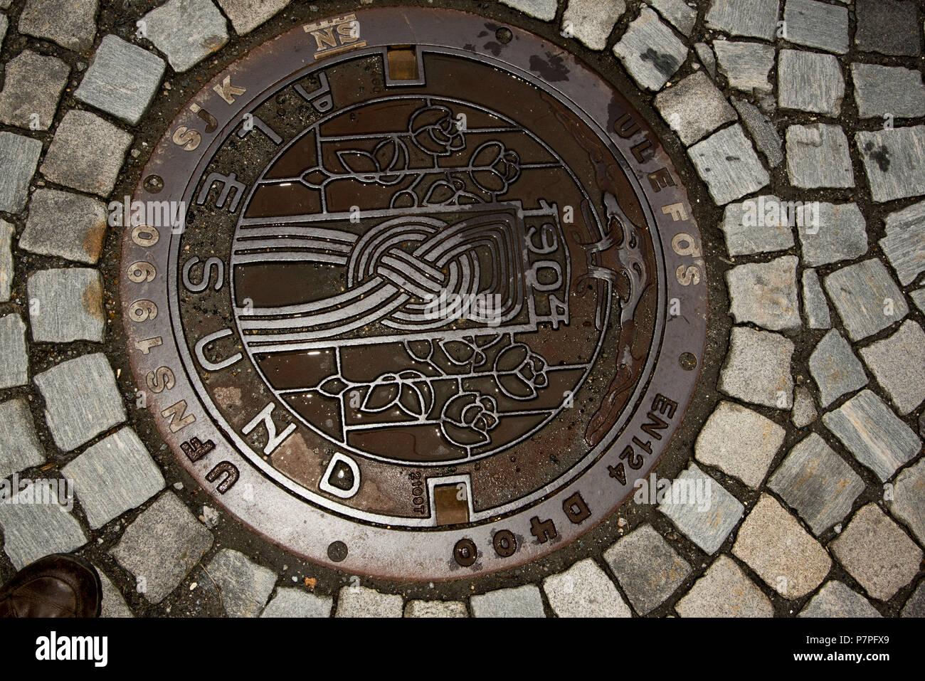 Roses and tower shown on manhole cover in Ålesund. Stock Photo