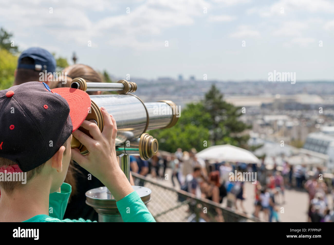 Boy looking through an observation telescope at Paris city skyline Stock Photo