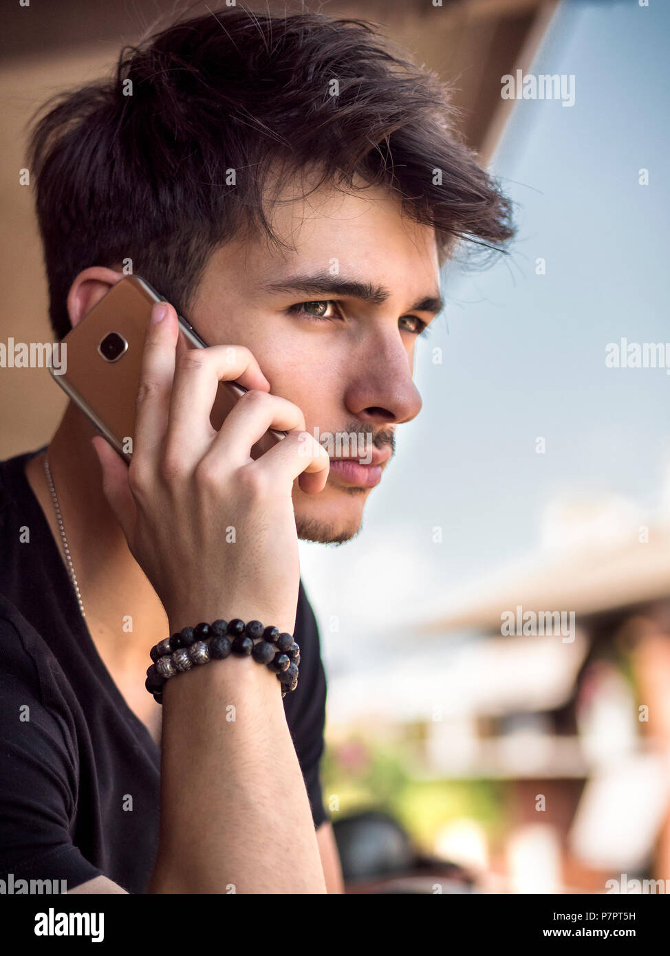 Young man outdoors talking on cell phone Stock Photo
