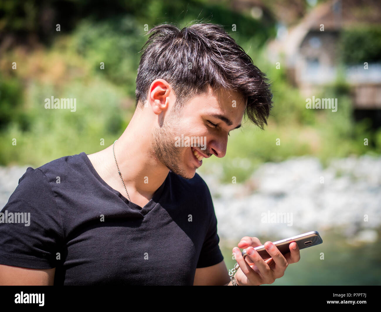 Young man in park using cell phone Stock Photo