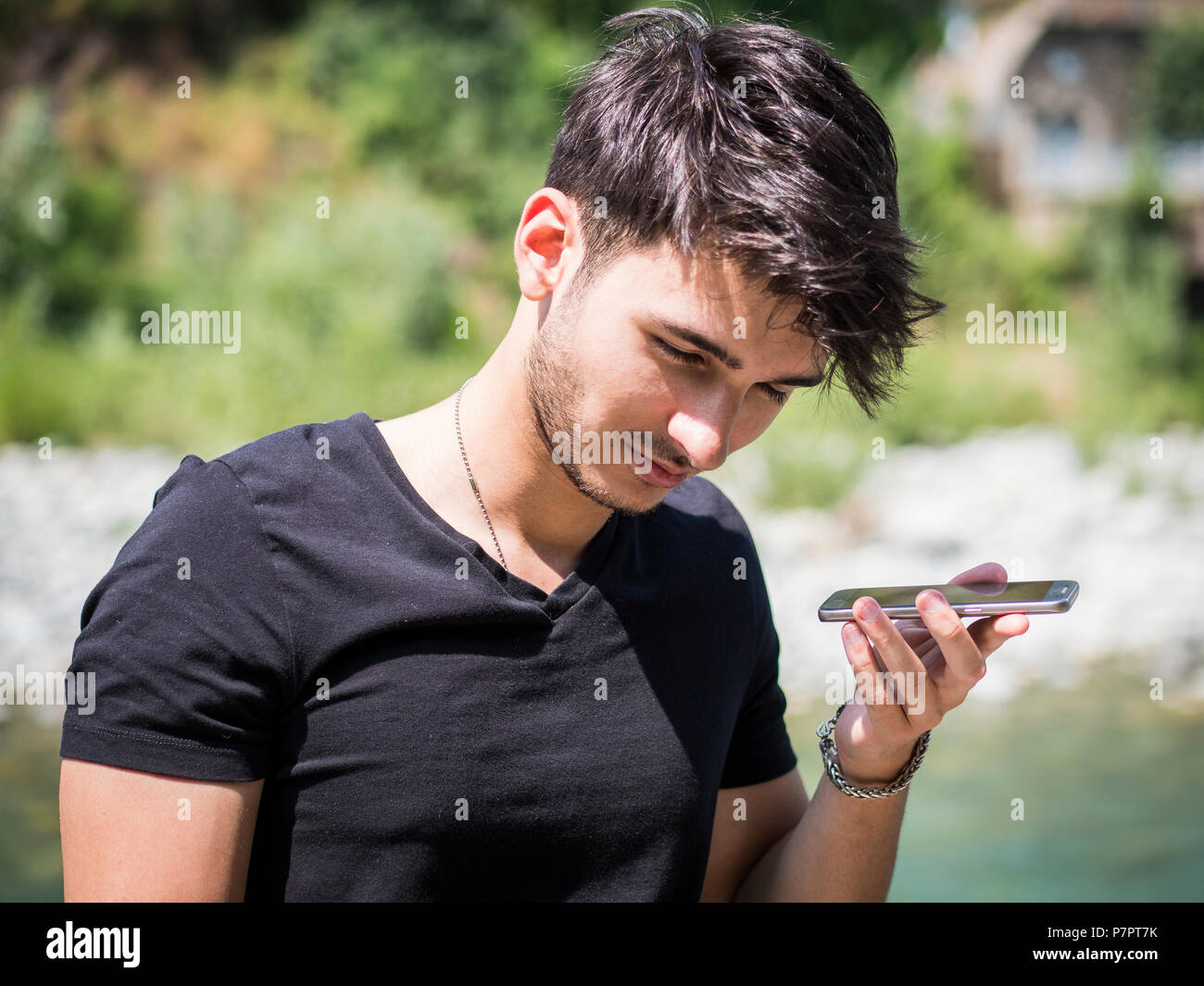 Young man in park using cell phone Stock Photo