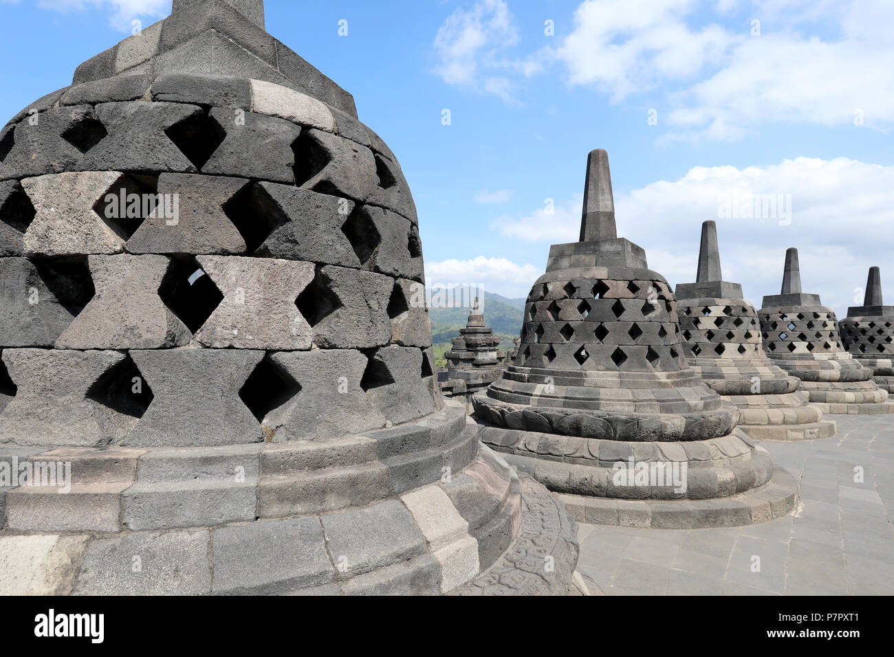 Borobudur, Indonesia - June 23, 2018: Perforated stupas – each containing a statue of Buddha – on the upper level of the Buddhist temple of Borobudur, Stock Photo