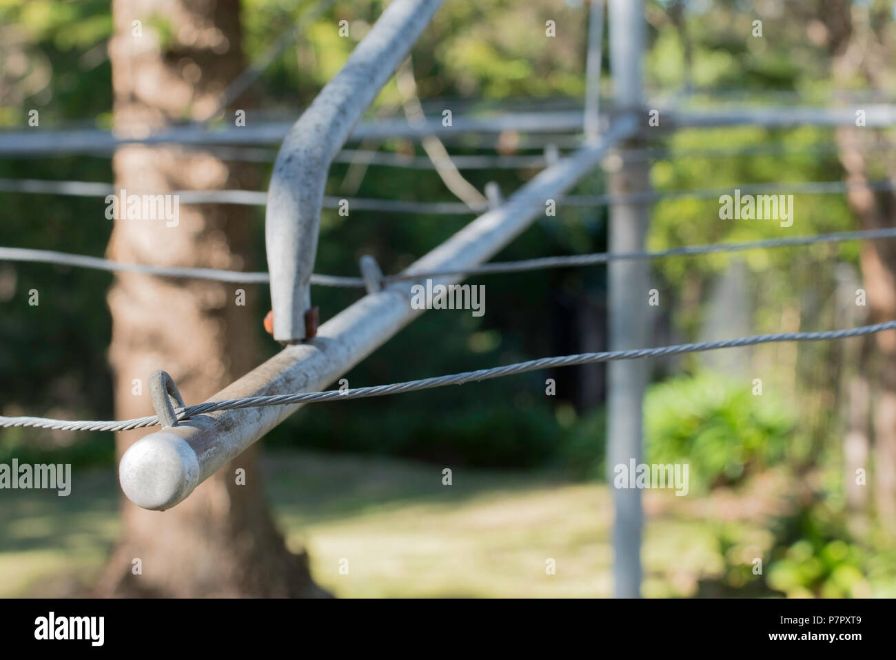 looking up at a partial view of the wire line and wings or arms of a Hills Hoist backyard clothes drying line in Australia Stock Photo