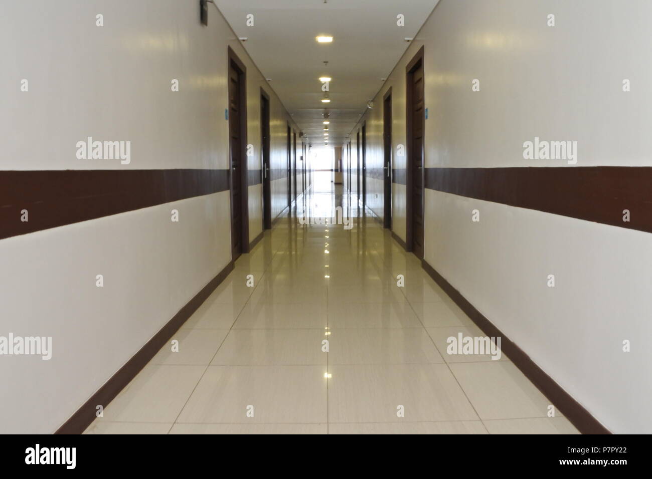 A symmetrical shot featuring rooms on both sides, leading to an open end bathed in abundant natural light. Stock Photo