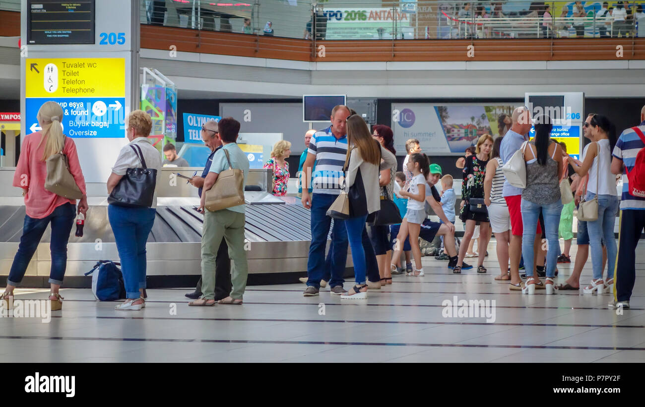 Antalya, Turkey - July 29, 2016: The queue to the luggage registration table at the airport. Crowd of people waiting, checking their social media, tal Stock Photo