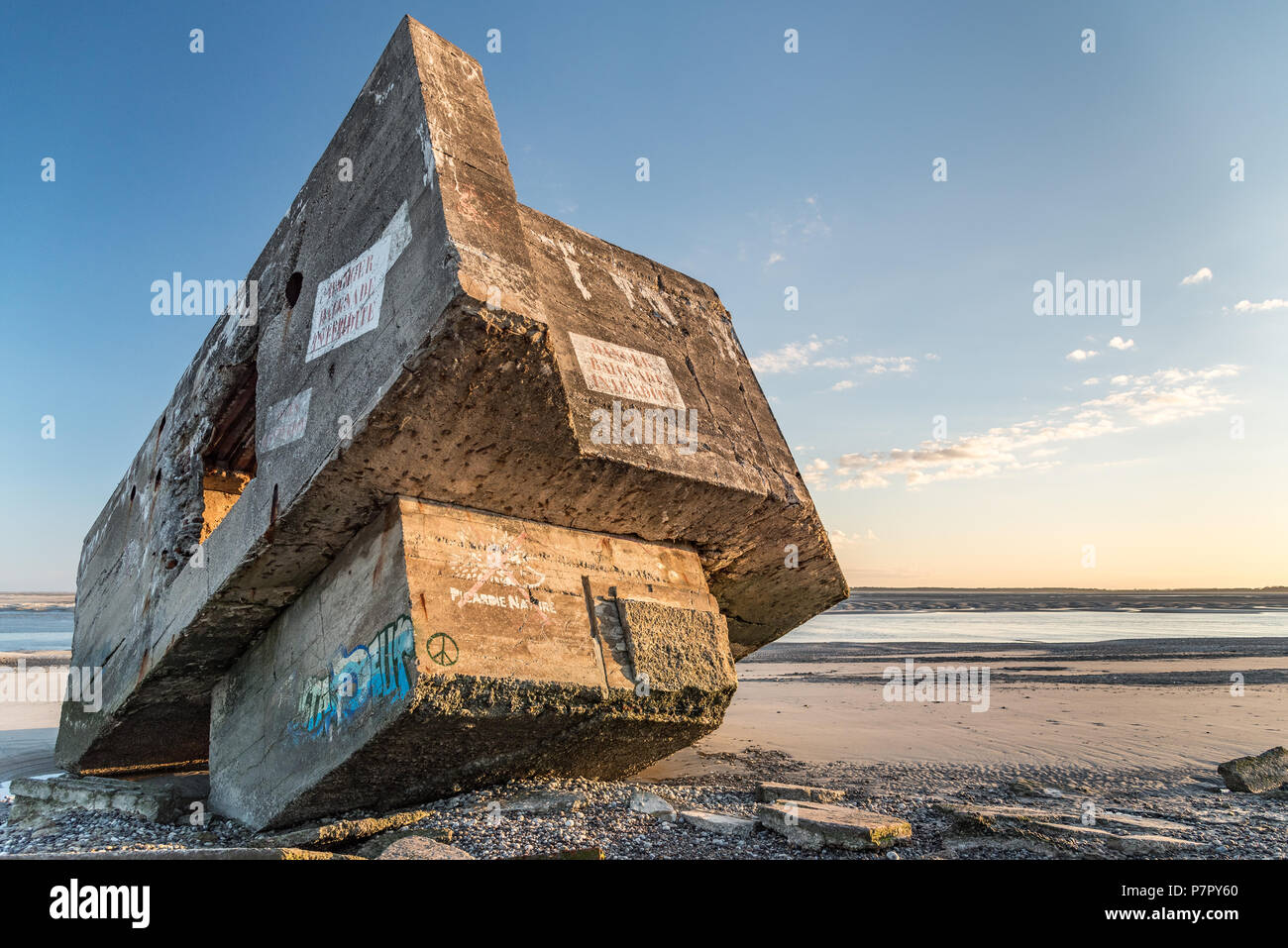 The ruins of a WWII German bunker seem to be stranded on a beach in the Bay of Somme. It is covered with graffiti Stock Photo