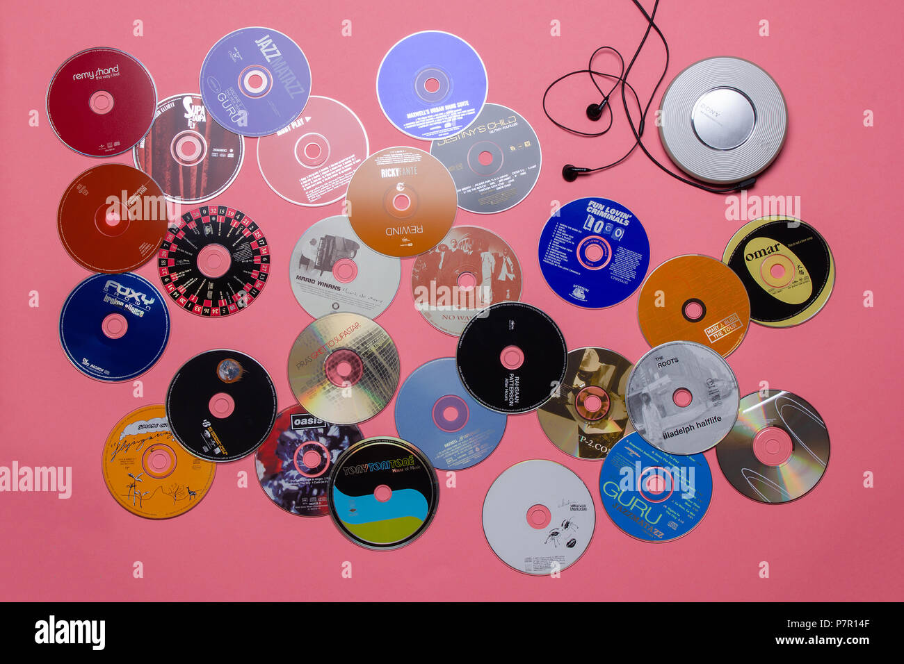 a fantastic top view of a 90's sony diskman and audio cd's on a pink background Stock Photo