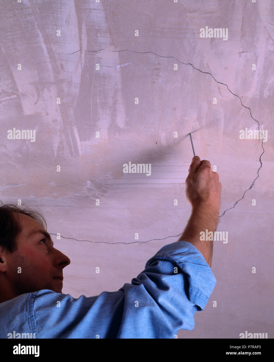 Man Marking Out Ceiling Before Replacing The Ceiling Rose For