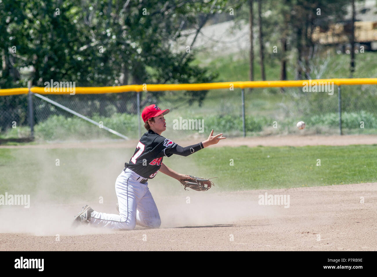 Shortsto tossing ball to second base,l boys afternoon junior baseball game. Cranbrook, BC. Stock Photo