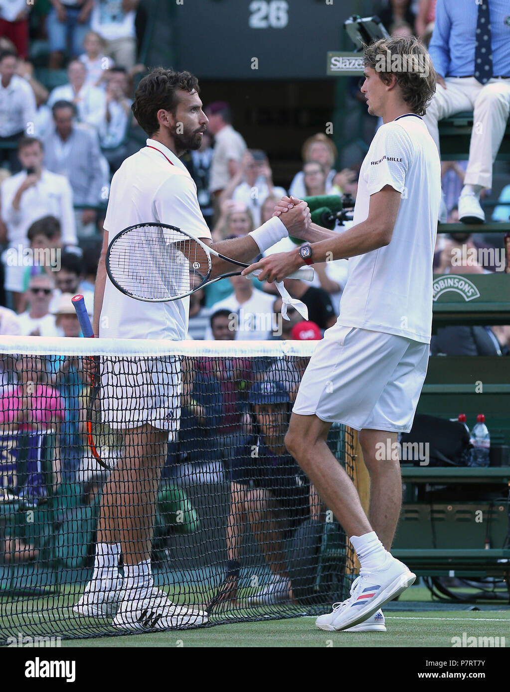 Ernests Gulbis celebrates shakes hands with Alexander Zverev after his win on day six of the Wimbledon Championships at the All England Lawn Tennis and Croquet Club, Wimbledon. PRESS ASSOCIATION Photo. Picture date: Saturday July 7, 2018. See PA story TENNIS Wimbledon. Photo credit should read: Jonathan Brady/PA Wire. Stock Photo