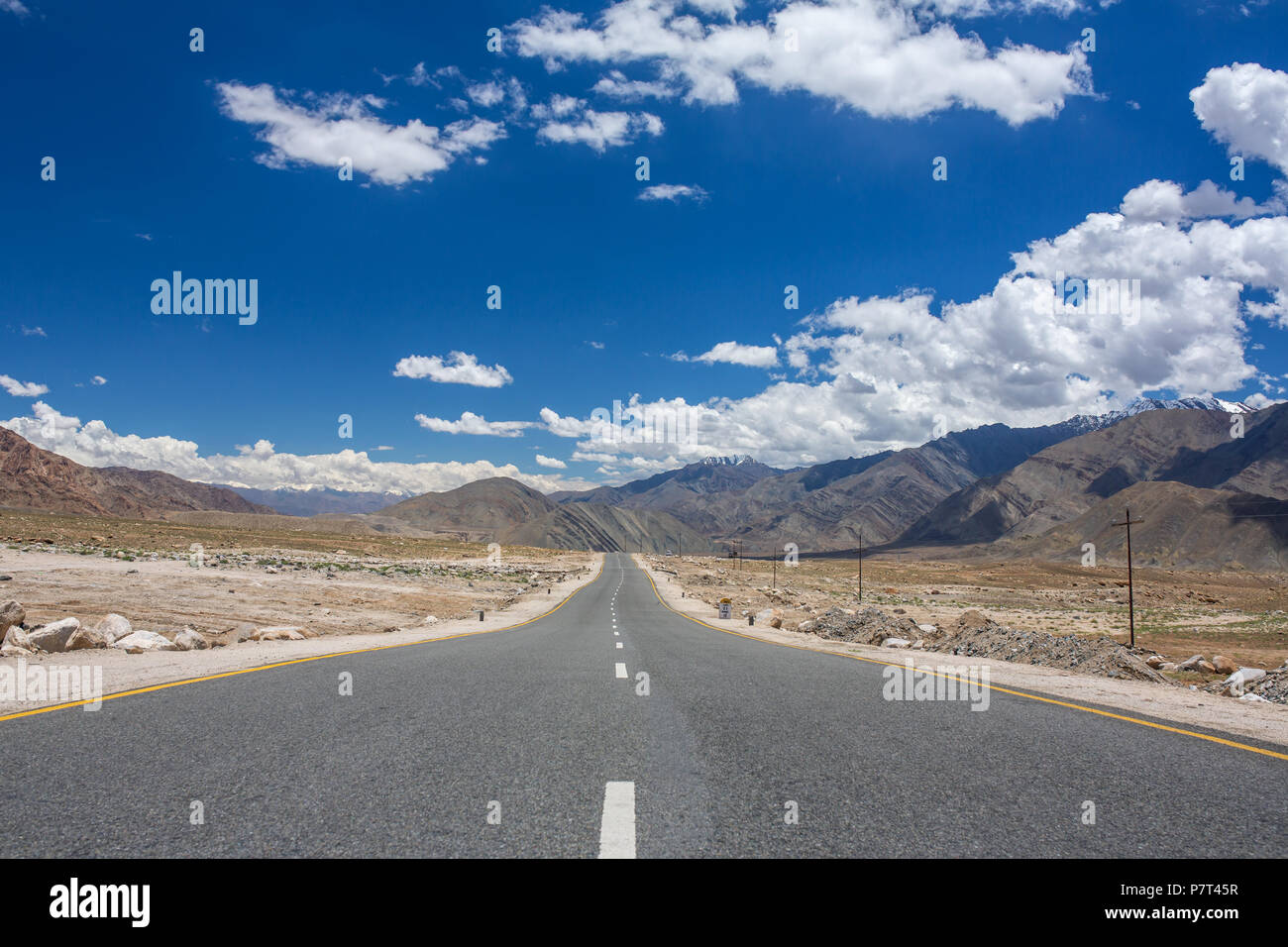 Emty road vanishing into HImalayas mountains in Ladakh, Northern India. Road trip concept Stock Photo
