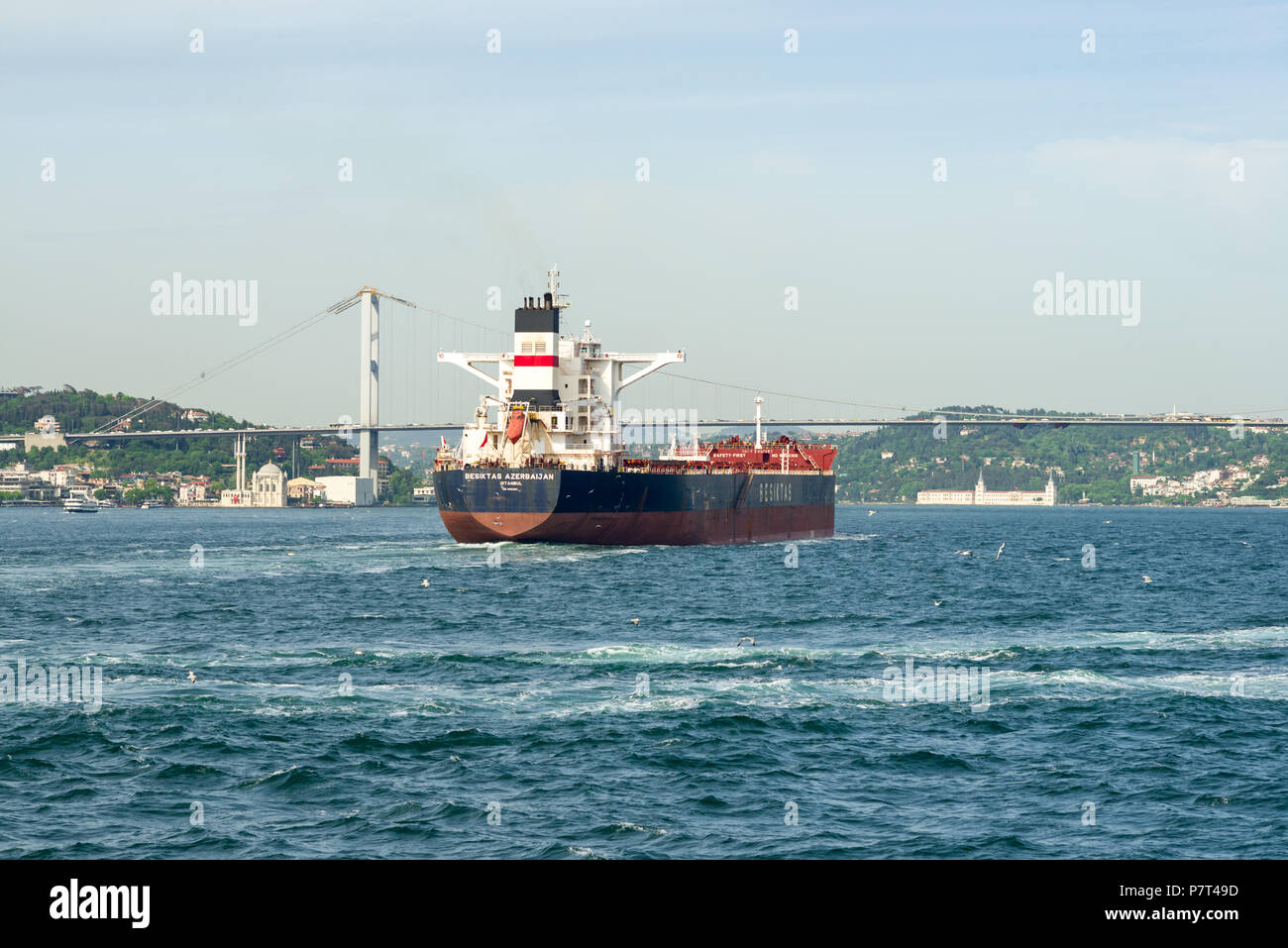 A large oil tanker transportation ship sails on the Bosphorus strait towards the 15 July Martyrs Bridge, Istanbul, Turkey Stock Photo