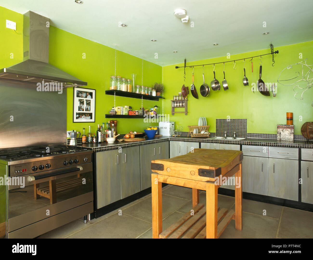 Butcher's block in lime green nineties kitchen with stainless steel range oven Stock Photo