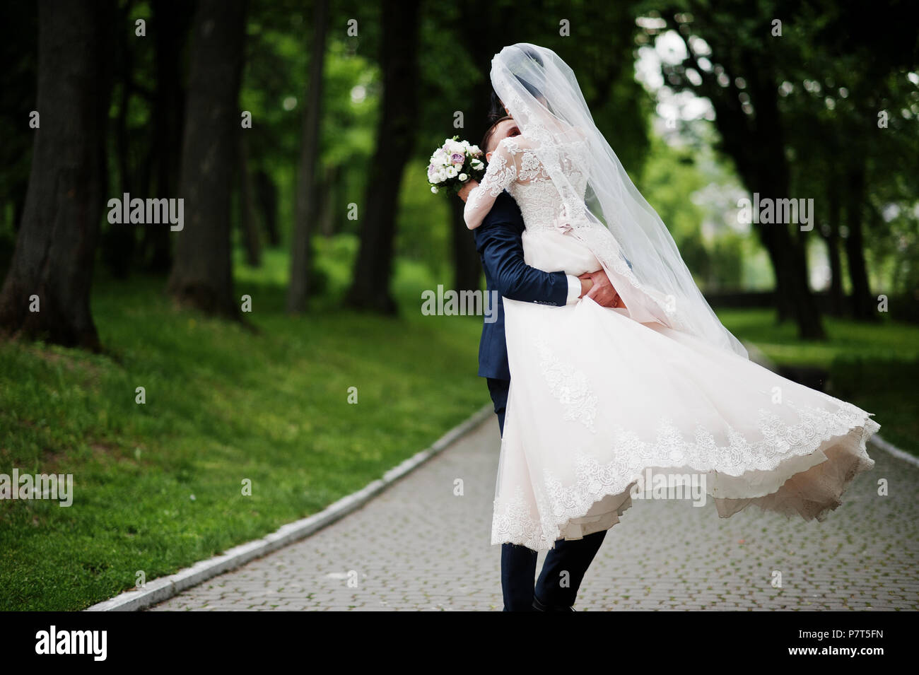 Romantic newly married couple dancing in the park on their wedding day ...