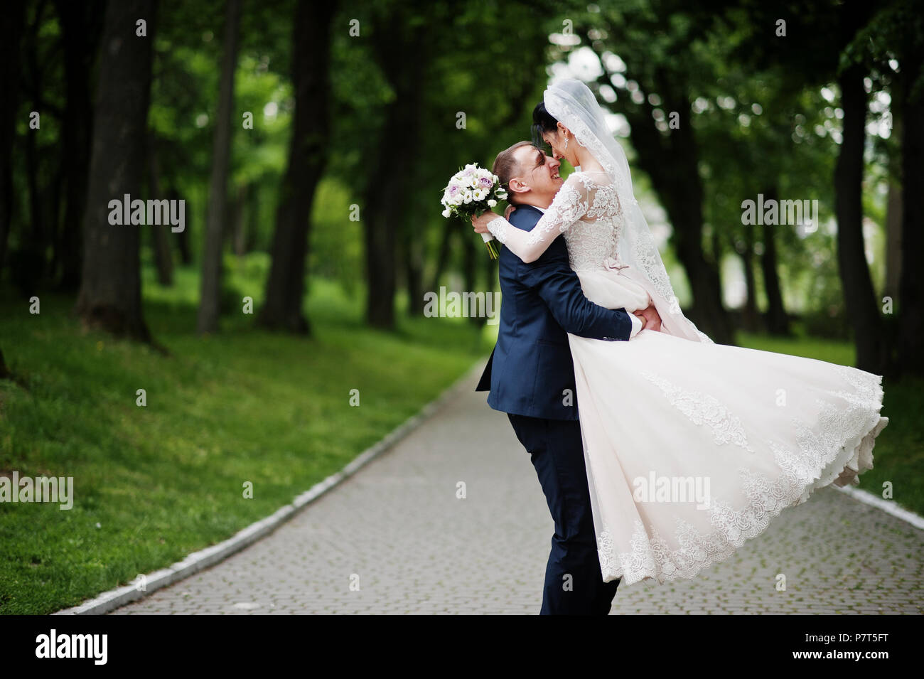 Romantic newly married couple dancing in the park on their wedding day ...