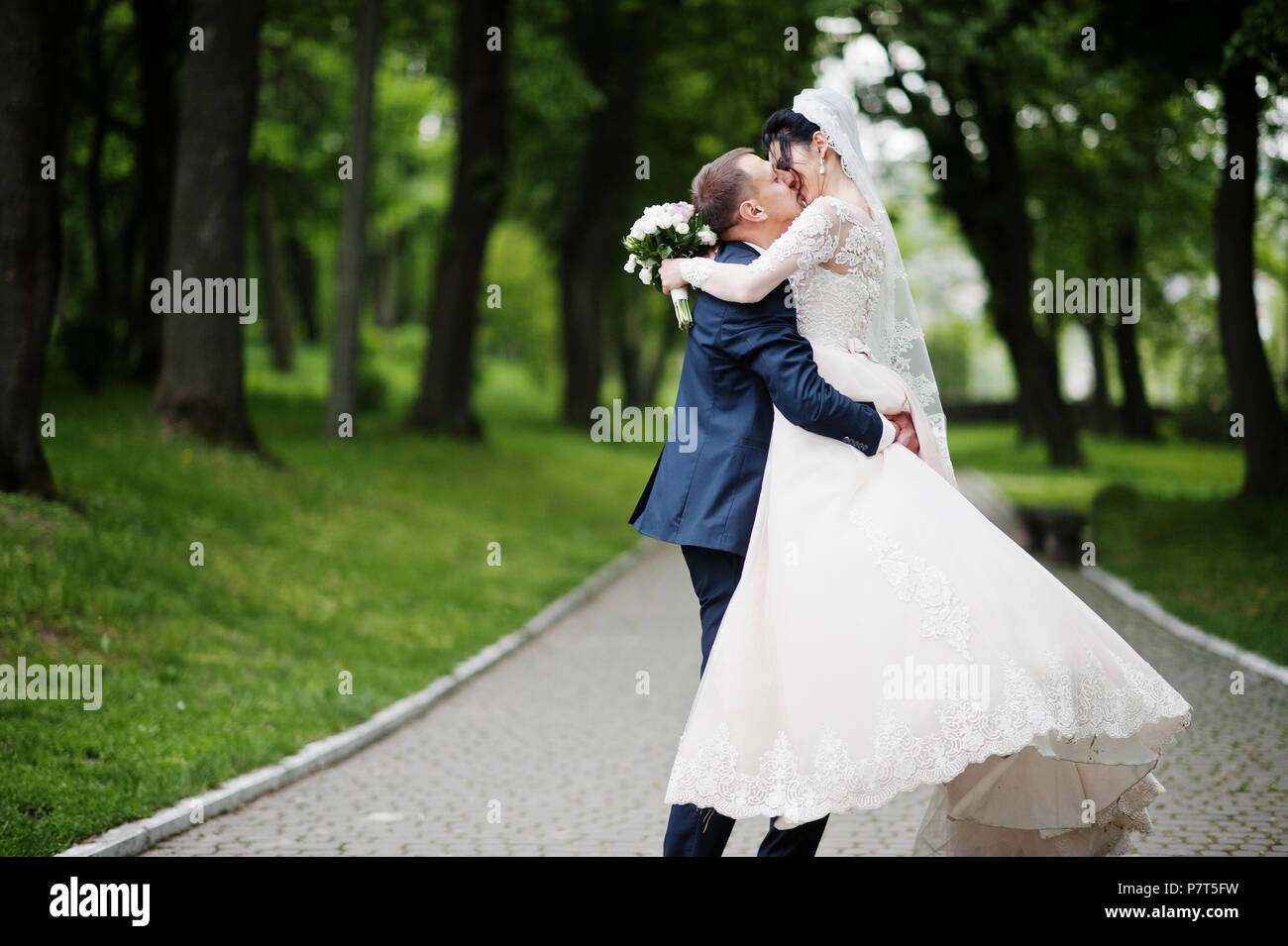 Romantic newly married couple dancing in the park on their wedding day ...
