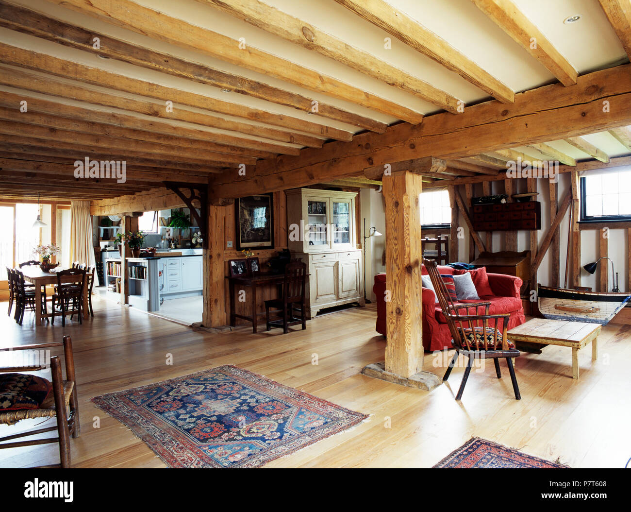 Rustic wooden beams in large open-plan living and dining room in converted barn Stock Photo