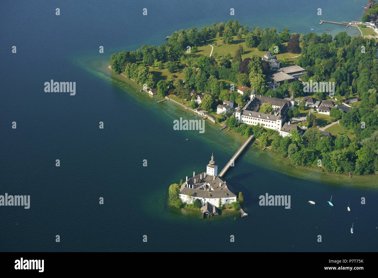 AERIAL VIEW. Medieval castle on a lake with a footbridge for access. Ort Castle, Gmunden, Traunsee (lake), Upper Austria, Austria. Stock Photo