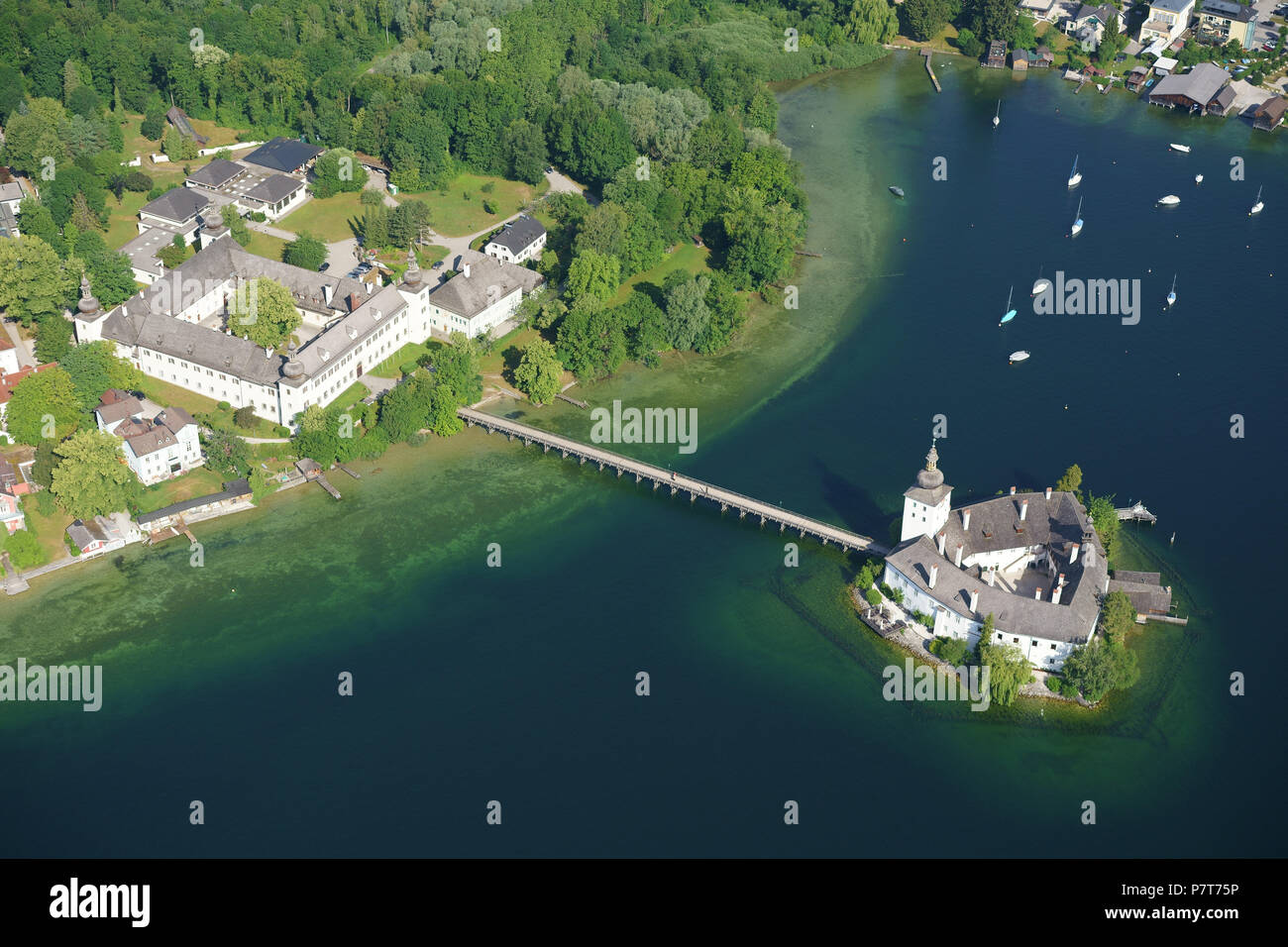 AERIAL VIEW. Medieval castle on a lake with a footbridge for access. Ort Castle, Gmunden, Traunsee (lake), Upper Austria, Austria. Stock Photo