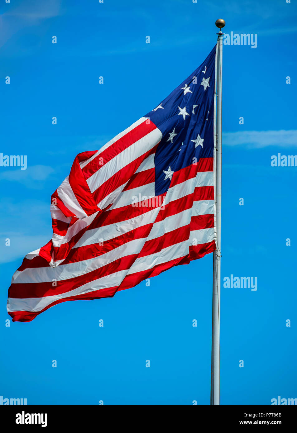 A photograph of a very large American Flag flying high on the beautiful day. Stock Photo