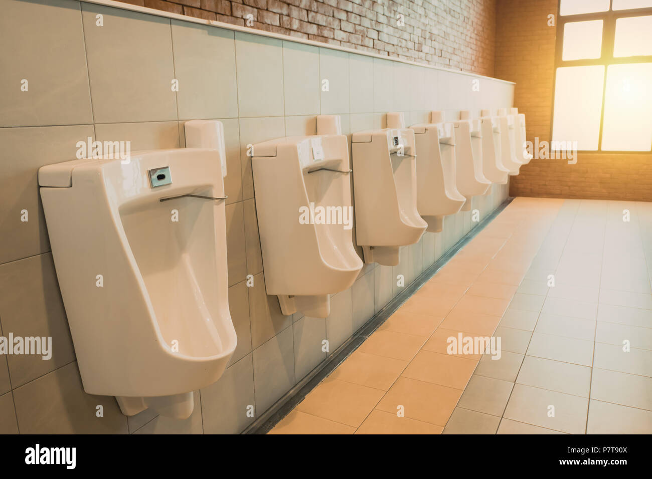 Male toilet sink with row of men urinals space in restroom Stock Photo