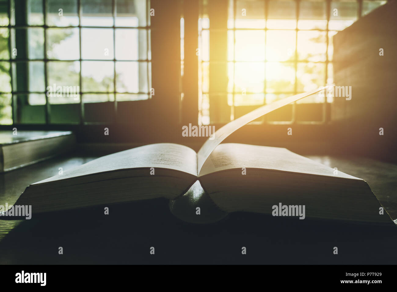Book at the windows sun bright vintage colortone Stock Photo