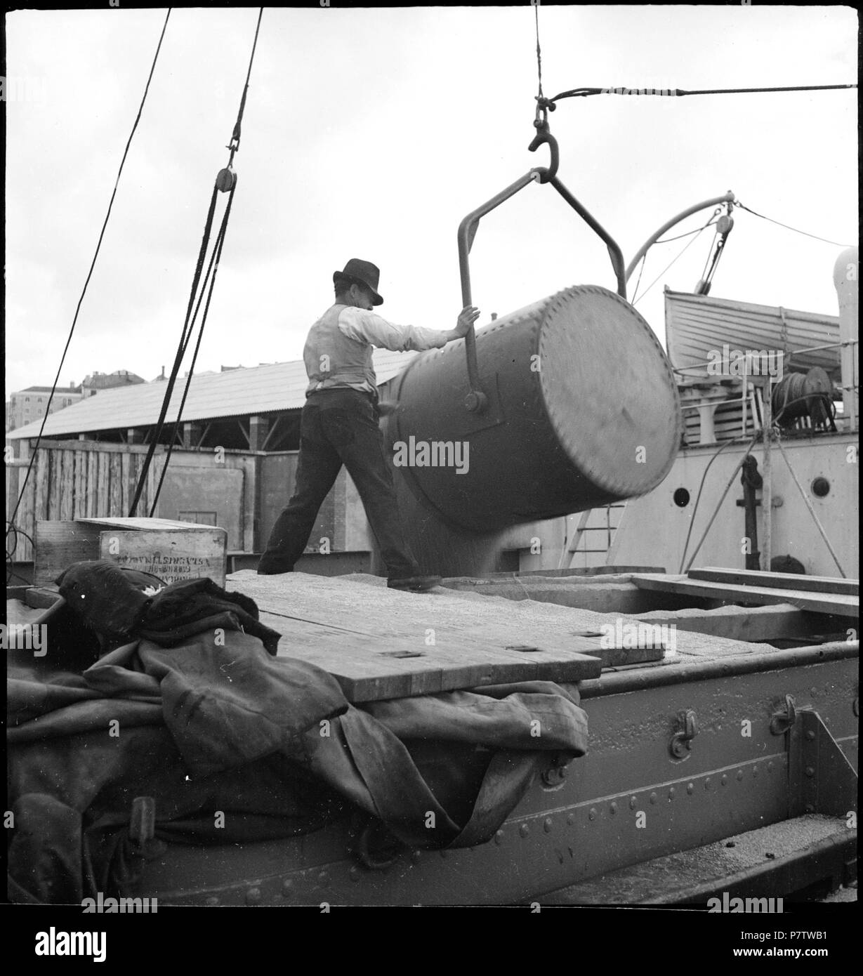 Portugal, Lissabon (Lisboa): Hafen; Ein Mann lädt aus einem Behälter, der an einem Kran hängt, Ware in ein Schiff. May 1941 78 CH-NB - Portugal, Lissabon (Lisboa)- Hafen - Annemarie Schwarzenbach - SLA-Schwarzenbach-A-5-24-076 Stock Photo