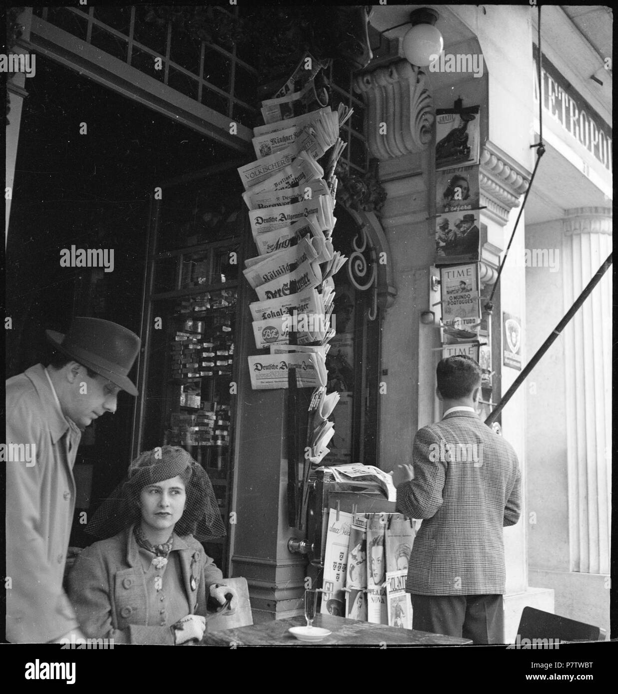 Portugal, Lissabon (Lisboa): Markthalle; Eine Frau an einem Tisch, daneben zwei Männer, im Hintergrund deutsche Zeitungen. May 1941 78 CH-NB - Portugal, Lissabon (Lisboa)- Markthalle - Annemarie Schwarzenbach - SLA-Schwarzenbach-A-5-24-052 Stock Photo