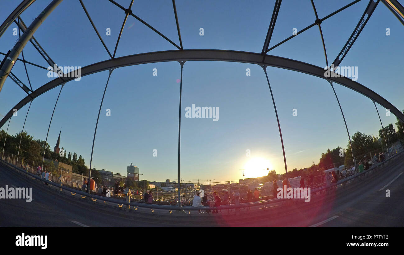 Berlin, Germany. 02nd July, 2018. People sit on the Modersohn Bridge to watch the sun set. Credit: Paul Zinken/dpa/Alamy Live News Stock Photo