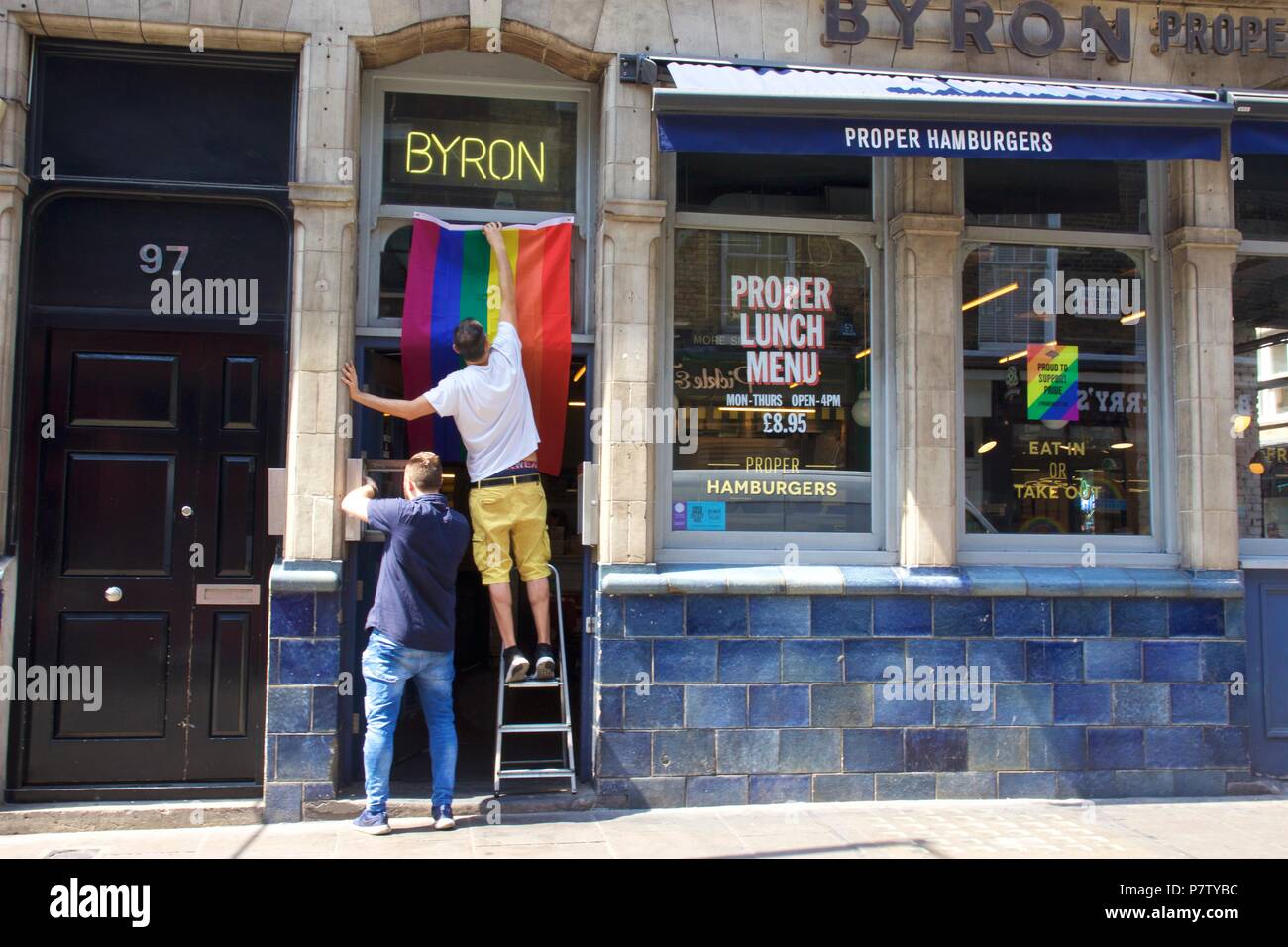 London, UK. 7th July 2018. Pride celebrations in London. Byron Burger on Wardour Street, Soho, London putting up their rainbow flag to celebrate Pride in London 2018. Credit: Dimple Patel/Alamy Live News Stock Photo