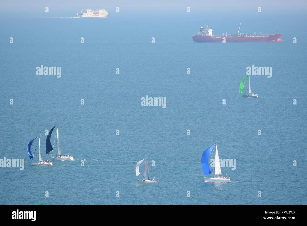 Culver Down, UK. 07th July, 2018. Yachts passing the eastern most point of the Island during the 'Round The Island Yacht Race' 2018. Photograph taken from Culver Down on the Isle of Wight overlooking Whitecliff Bay and Portsmouth as the yachts sail through the Solent Channel towards the finish line in Cowes. Credit: Matthew Blythe/Alamy Live News Stock Photo