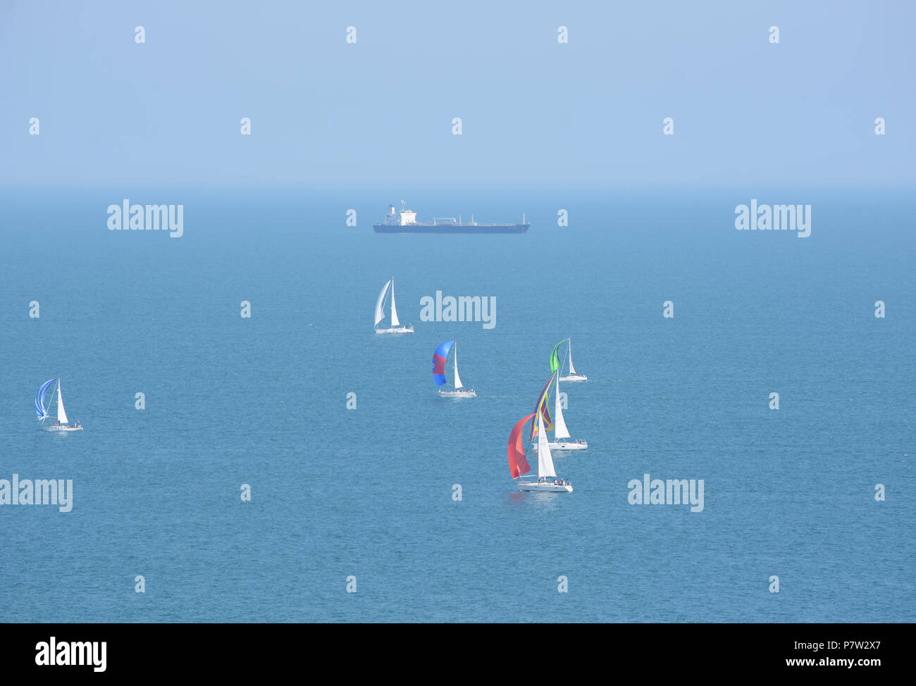 Culver Down, UK. 07th July, 2018. Yachts passing the eastern most point of the Island during the 'Round The Island Yacht Race' 2018. Photograph taken from Culver Down on the Isle of Wight overlooking Whitecliff Bay and Portsmouth as the yachts sail through the Solent Channel towards the finish line in Cowes. Credit: Matthew Blythe/Alamy Live News Stock Photo