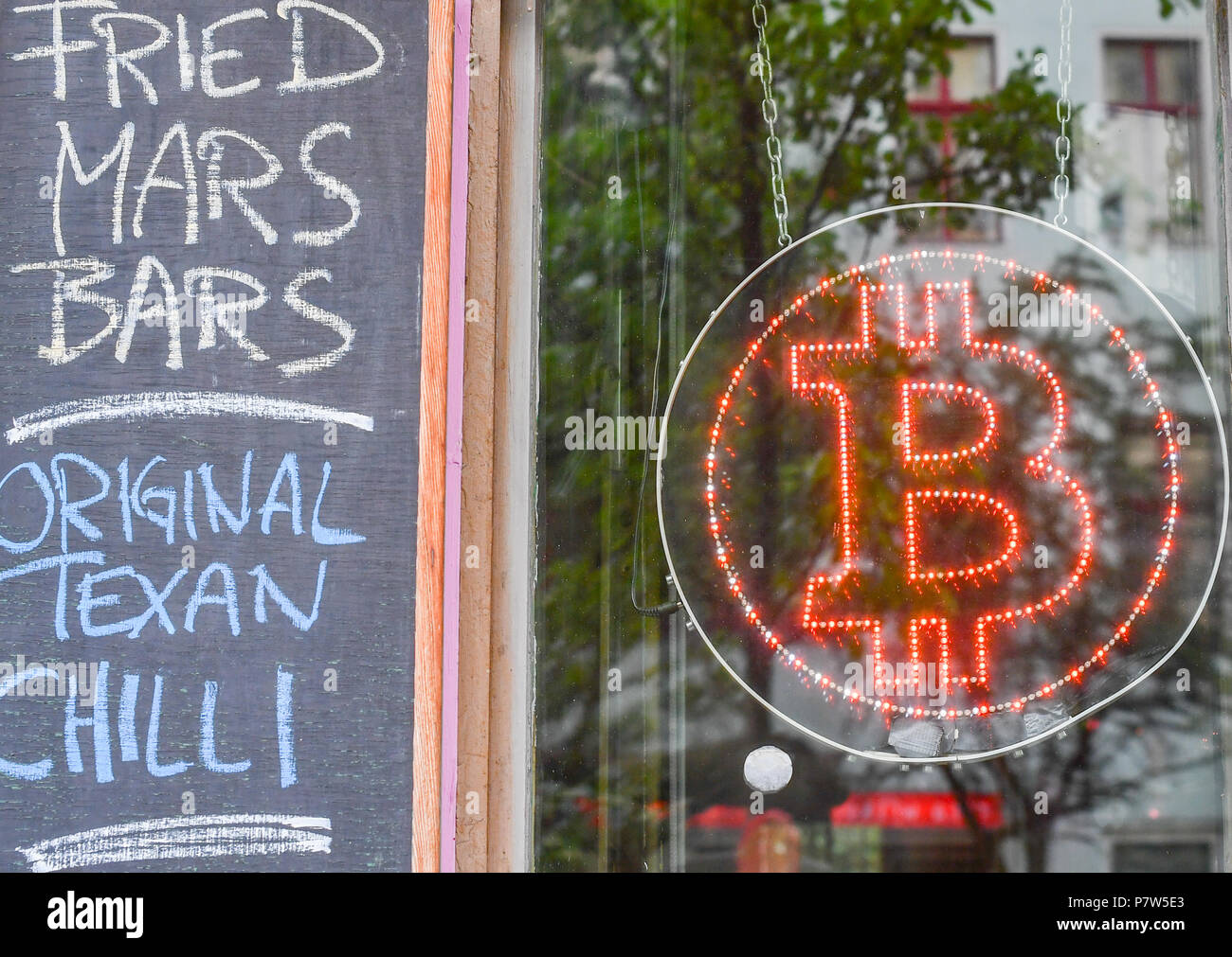 Germany, Berlin. 19th July, 2018. The logo of Bitcoin can be seen in the  window of the bitcoin bar 