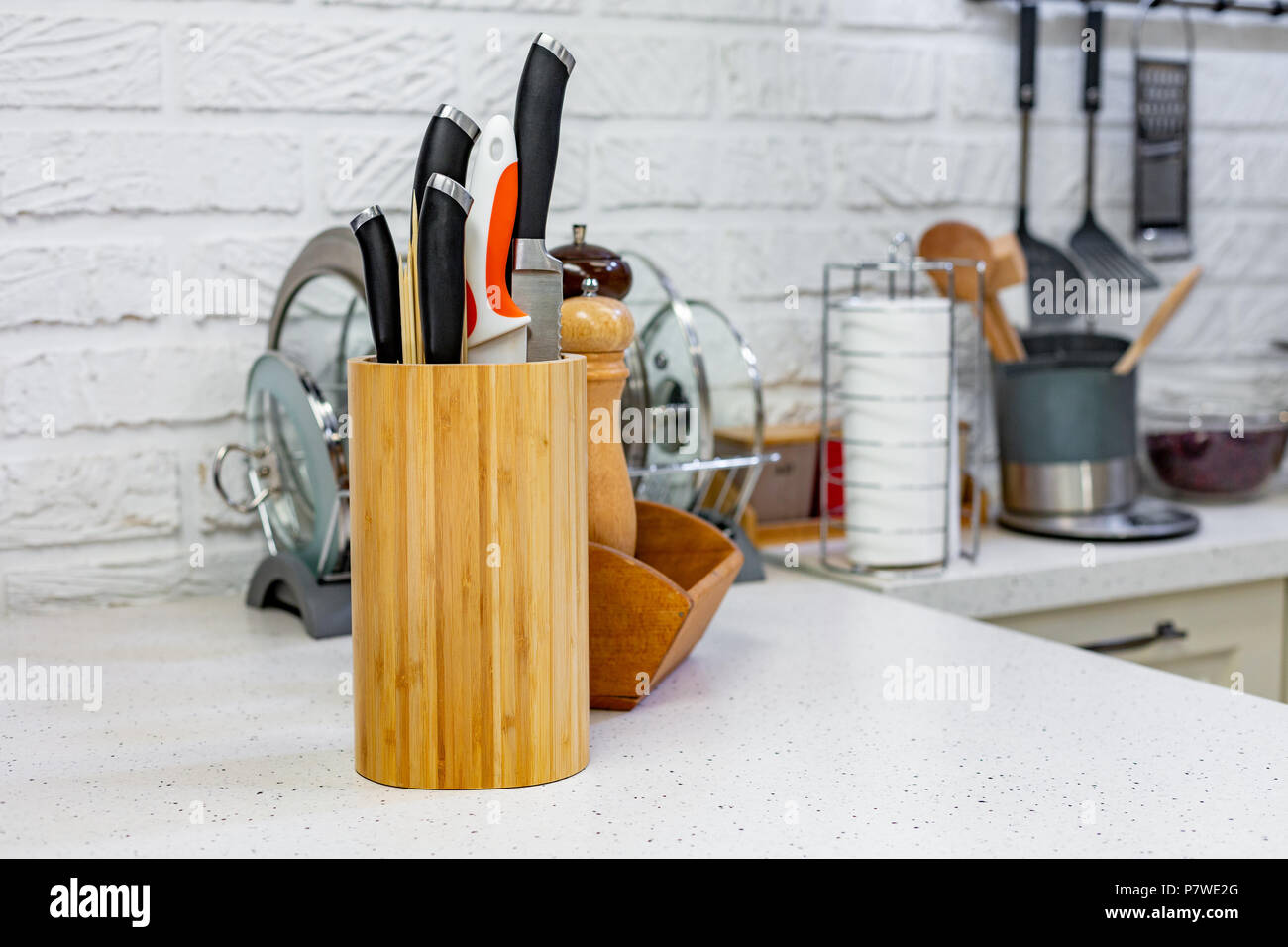 Kitchen knives in a special wooden stand with spice jars. Closeup