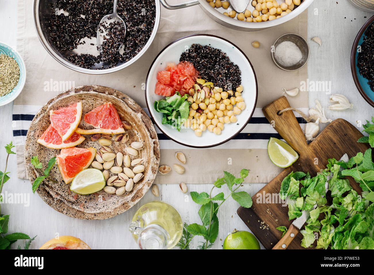 Ingredients for cooking vegetarian salad with black quinoa, chickpea, nuts and fruits on wooden table, top view. Superfood concept Stock Photo