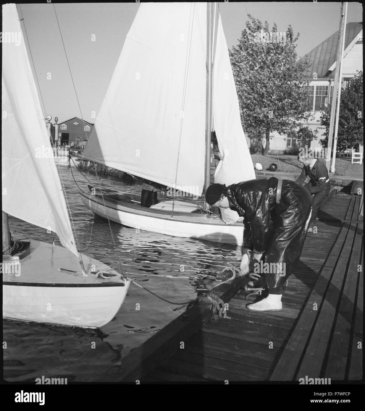 Finnland, Helsinki: Segeln; Ein Mann und eine Frau befestigen Segelboote. June 1937 70 CH-NB - Finnland, Helsinki- Segeln - Annemarie Schwarzenbach - SLA-Schwarzenbach-A-5-17-030 Stock Photo