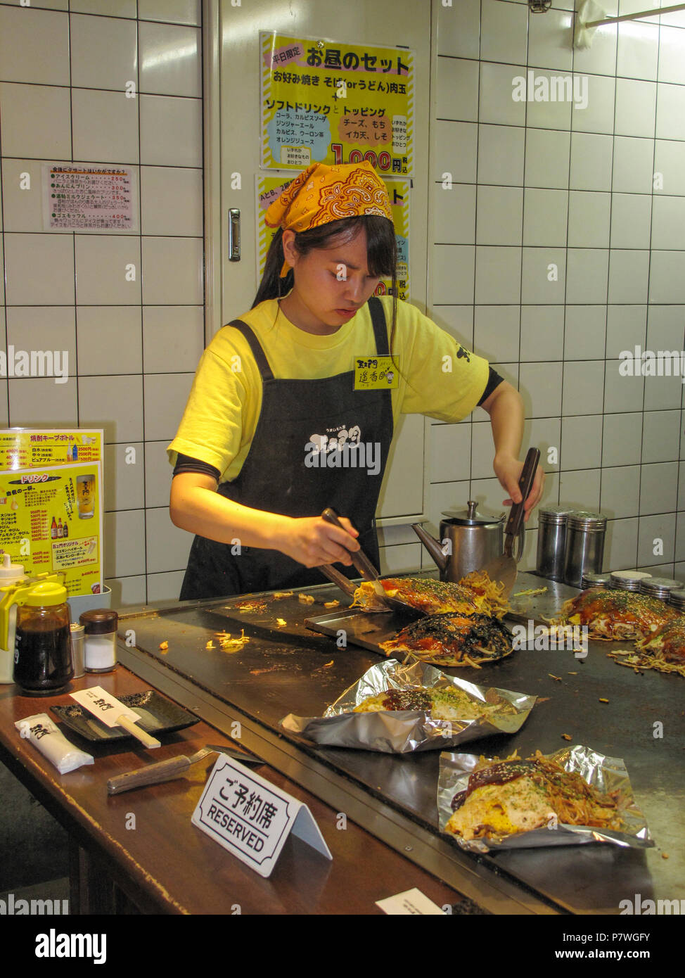 Restaurant kitchen, staff cooking Okonomiyaki savoury pancakes Stock Photo