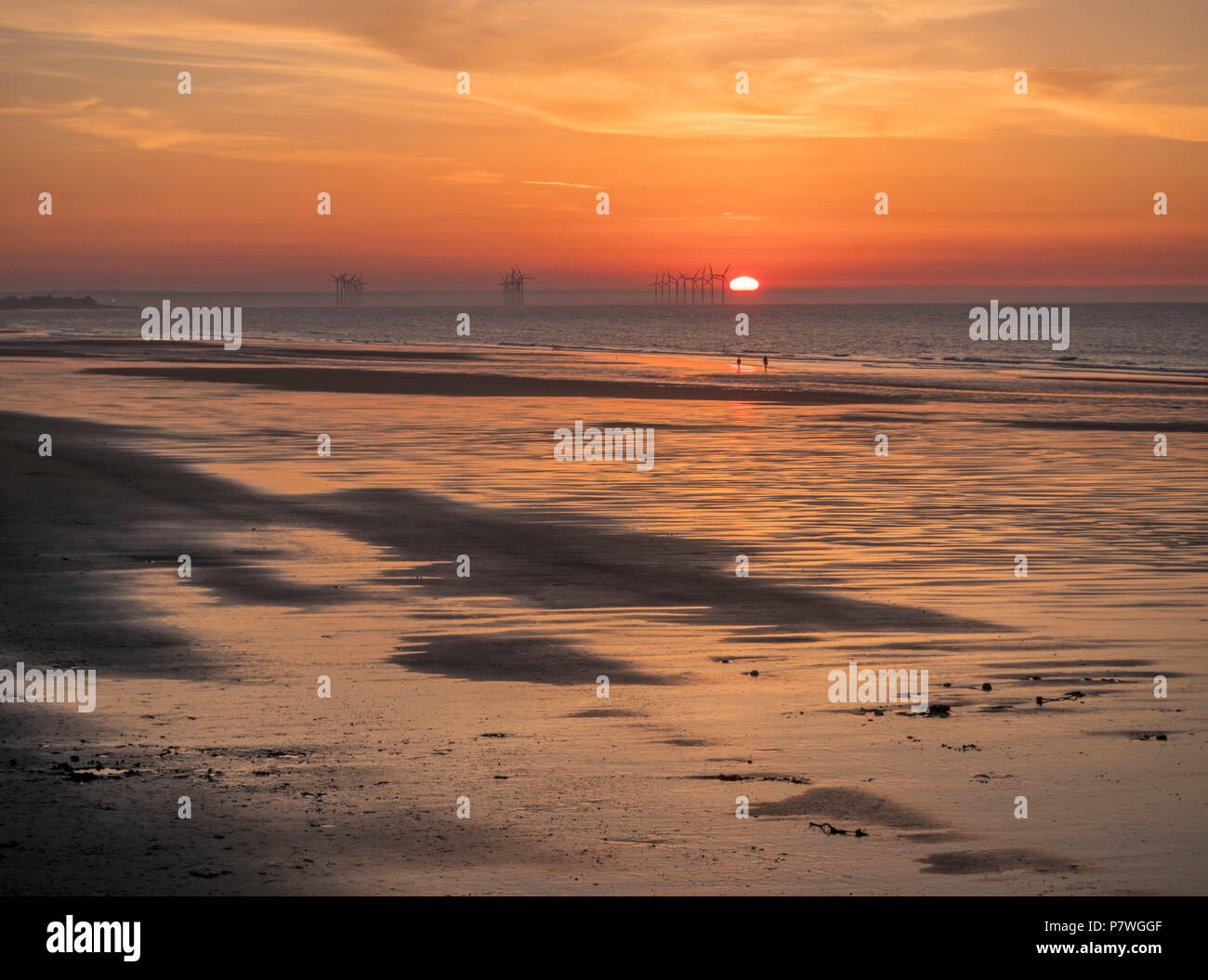 Sun setting over the horizon and North Sea at Saltburn beach Stock Photo