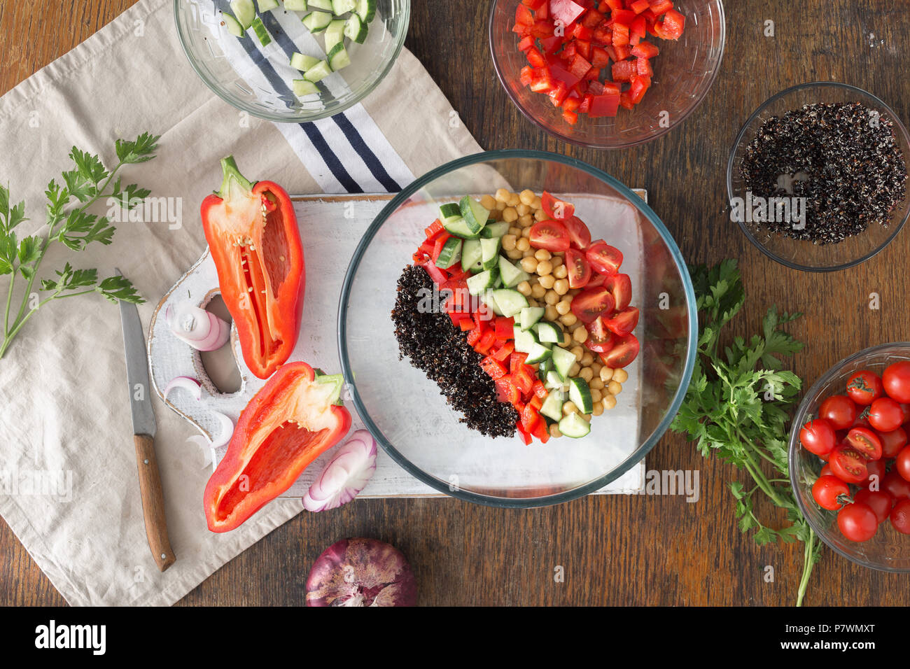 Black quinoa, chickpeas, peppers, cucumber, tomatoes and parsley on  wooden table top view. Summer Vegetarian Salad with Ingredients for cooking veget Stock Photo