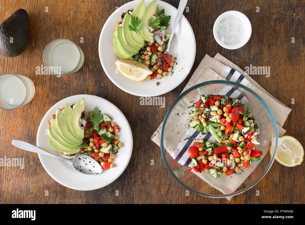 Summer Vegetarian Salad of Black quinoa, chickpeas, peppers, cucumber, tomatoes and parsley with avocado toast and homemade lemonade on wooden table t Stock Photo